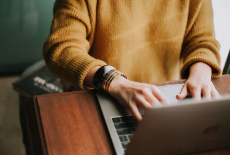 Woman using a laptop on a wooden table